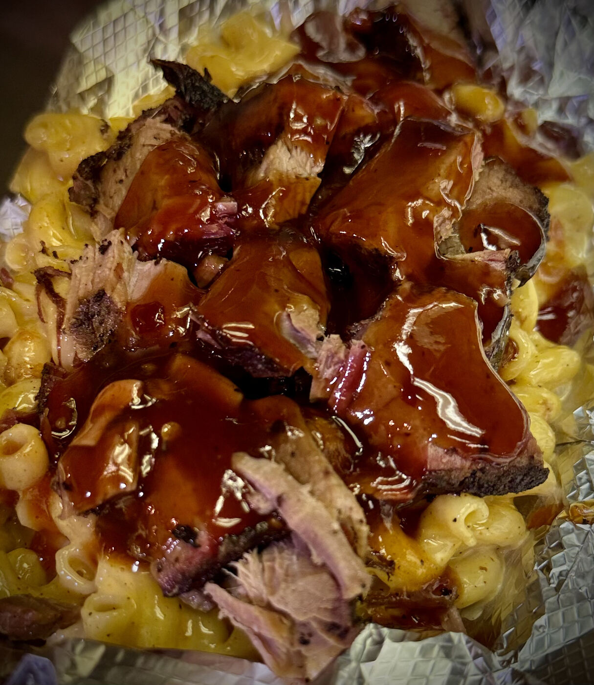 Smoked brisket over creamy mac and cheese with house BBQ sauce — Slap Yo Self BBQ